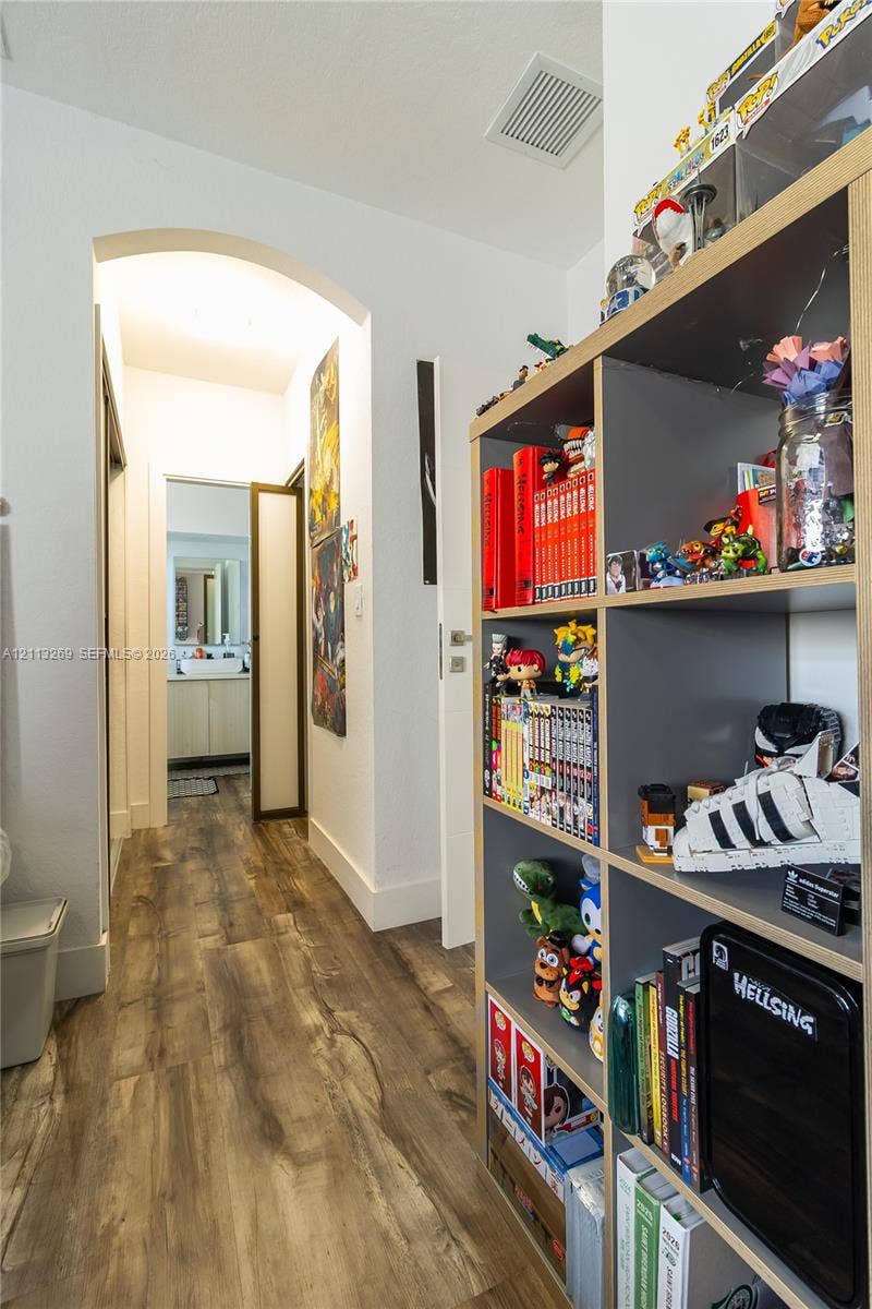 11494 NW 79th Lane, Doral, FL 33178 Hallway featuring wood-finish flooring and a prominent arched entryway