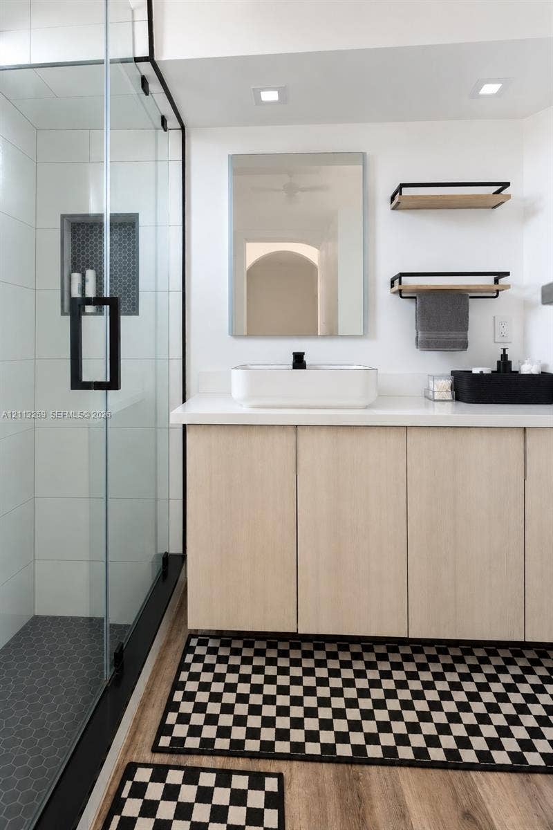 11494 NW 79th Lane, Doral, FL 33178 Vanity featuring light wood-finish cabinetry, a rectangular vessel sink, and a solid-surface countertop
