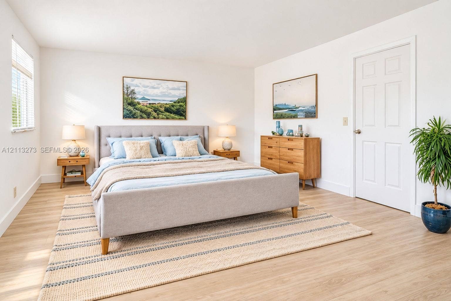 Wood-finish flooring, white walls, and a white six-panel interior door