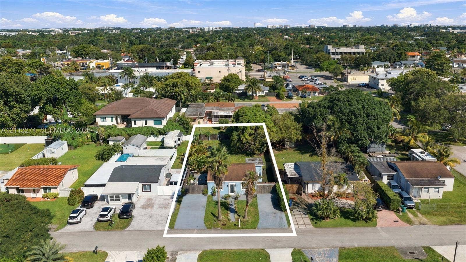 6521 SW 42nd Street, Miami, FL 33155 Aerial perspective of a detached property featuring dual paved driveways, established palms, and a fenced rear perimeter