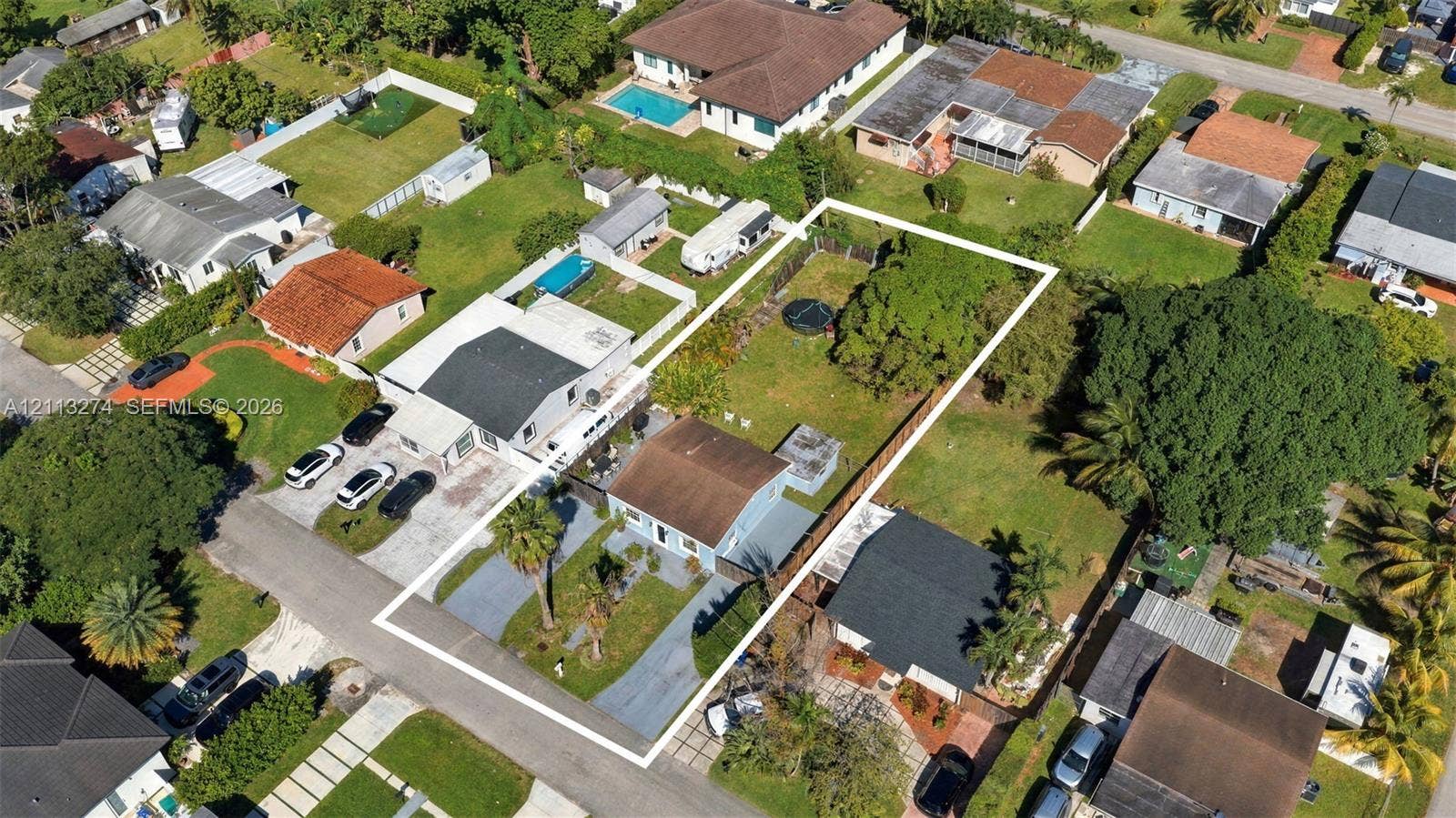 6521 SW 42nd Street, Miami, FL 33155 Aerial perspective of a property featuring an expansive rectangular lot, a paved driveway, and established mature trees