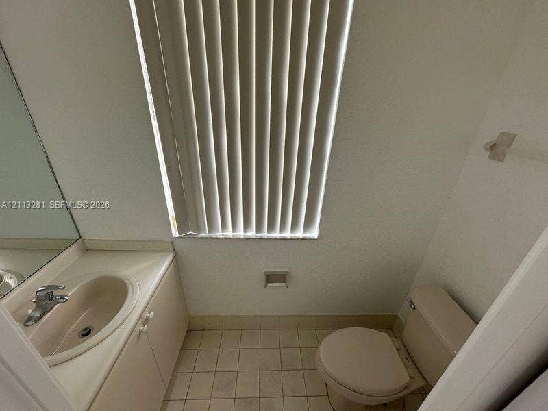 2615 SE 15th Place, #190, Homestead, FL 33035 Bathroom featuring a vanity with an integrated sink, polished chrome faucet, tile flooring, and vertical window blinds