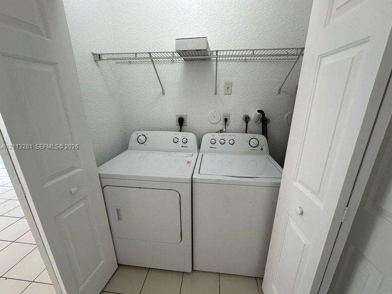 2615 SE 15th Place, #190, Homestead, FL 33035 Laundry closet featuring dual bifold doors, tile flooring, and integrated wire shelving