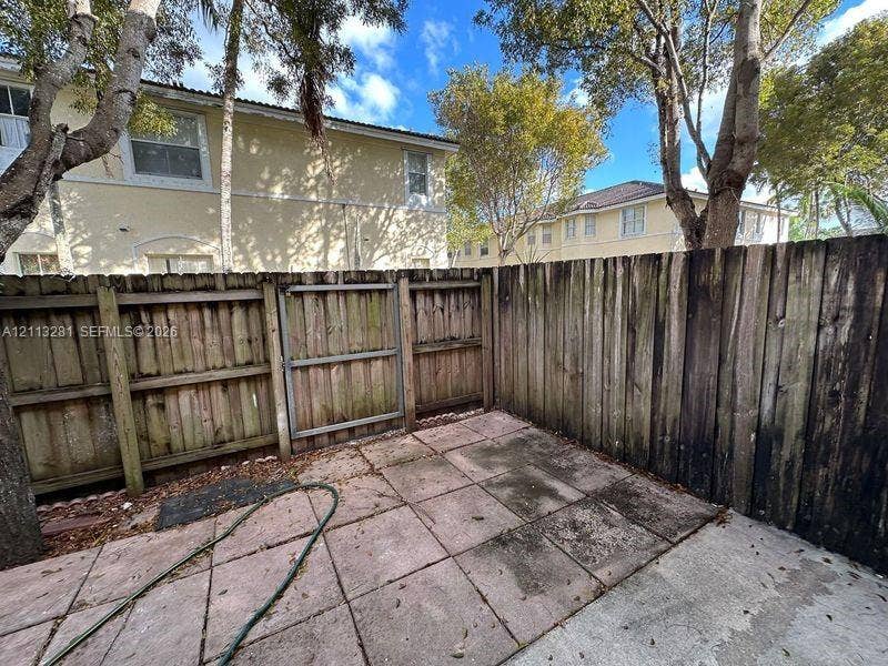 2615 SE 15th Place, #190, Homestead, FL 33035 Private outdoor patio featuring concrete paving, enclosed by a wood-plank privacy fence with a gated entry
