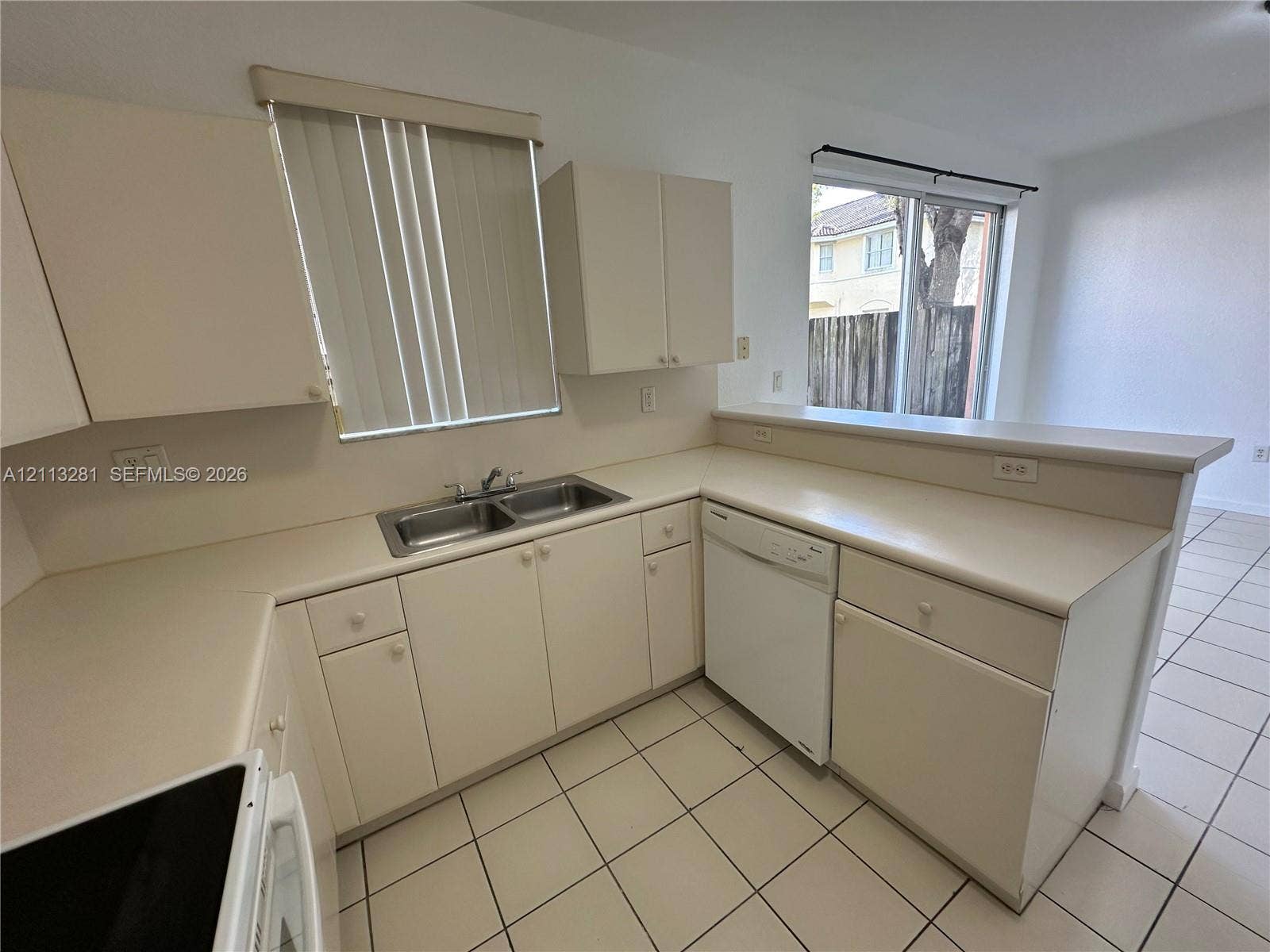 2615 SE 15th Place, #190, Homestead, FL 33035 Kitchen featuring solid-surface countertops, dual-basin stainless steel sink, tile flooring, and integrated dishwasher