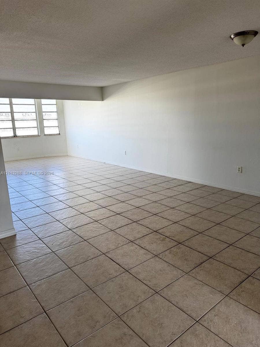Expansive room featuring large multi-pane windows and neutral ceramic tile flooring