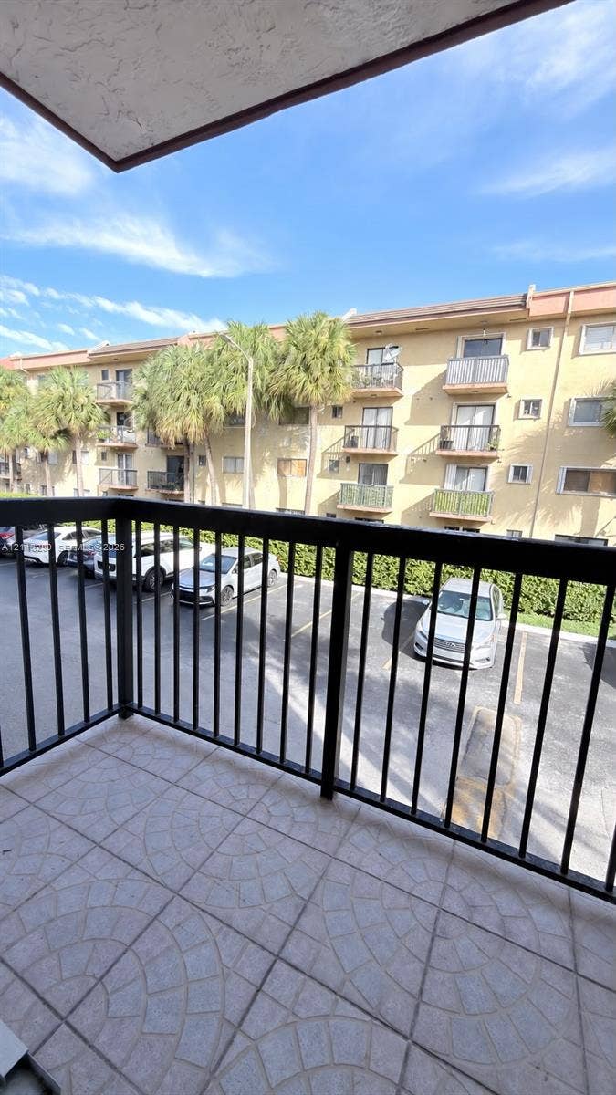5460 W 21st Court, #208, Hialeah, FL 33016 Private balcony with dark metal railings and decorative stone-tile flooring