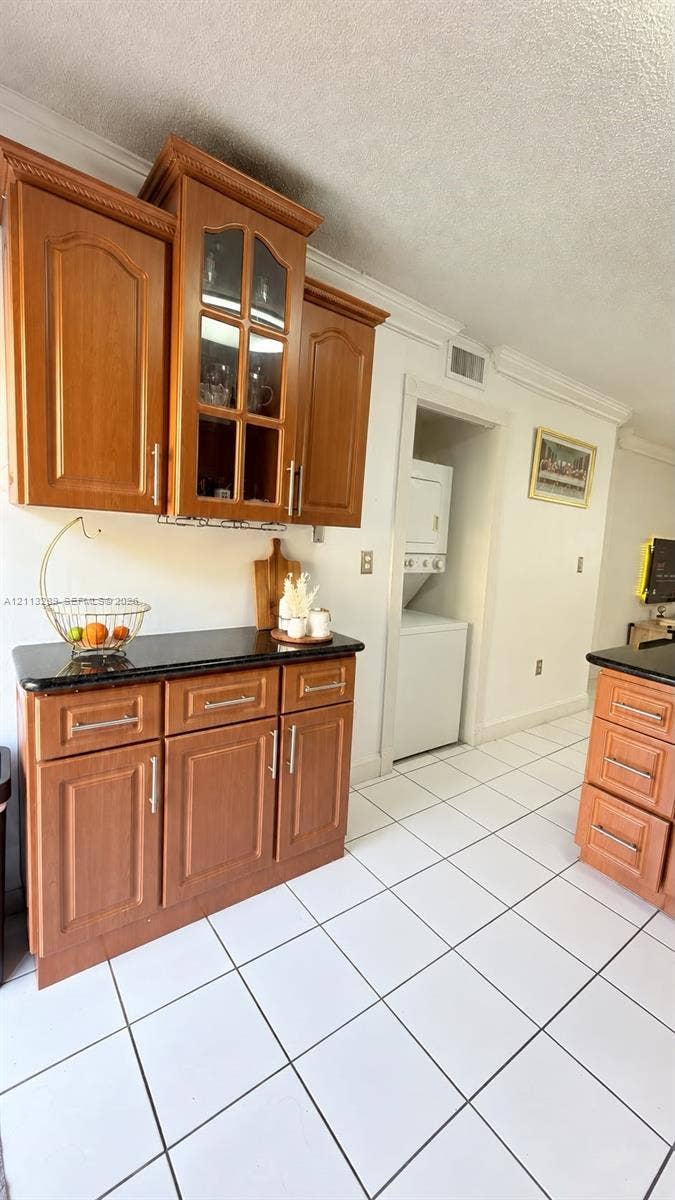 5460 W 21st Court, #208, Hialeah, FL 33016 Custom wood cabinetry with glass-paneled display doors, dark stone countertops, and tile flooring