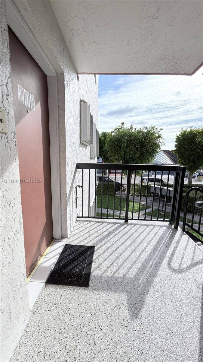 5460 W 21st Court, #208, Hialeah, FL 33016 Covered exterior landing with textured finish, metal railing, and direct entry door