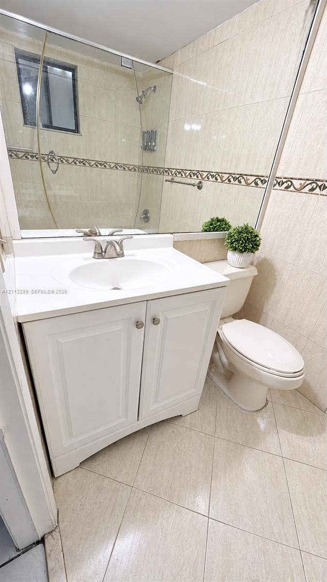 5460 W 21st Court, #208, Hialeah, FL 33016 Bathroom featuring a white vanity cabinet, integrated sink, large wall-mounted mirror, and tile flooring