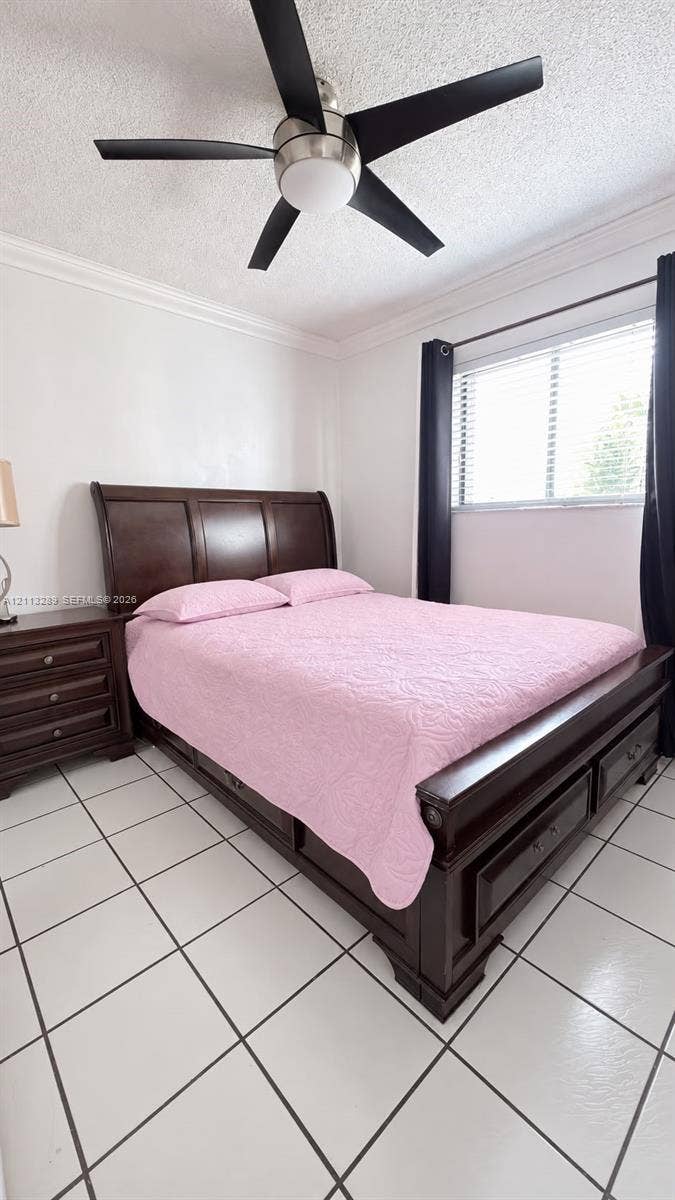 5460 W 21st Court, #208, Hialeah, FL 33016 Neutral-toned tile flooring, crown molding, and a multi-blade ceiling fan with integrated lighting