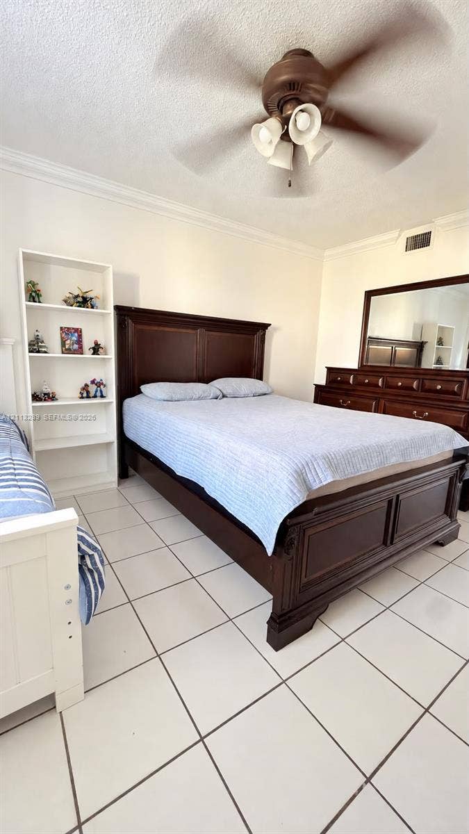 5460 W 21st Court, #208, Hialeah, FL 33016 White tile flooring, built-in shelving unit, and a ceiling fan with integrated light fixture