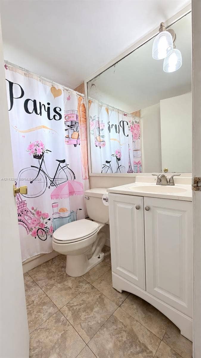 5460 W 21st Court, #208, Hialeah, FL 33016 Bathroom featuring a white vanity cabinet, integrated sink, dual-handle faucet, large wall-mounted mirror, and tile flooring