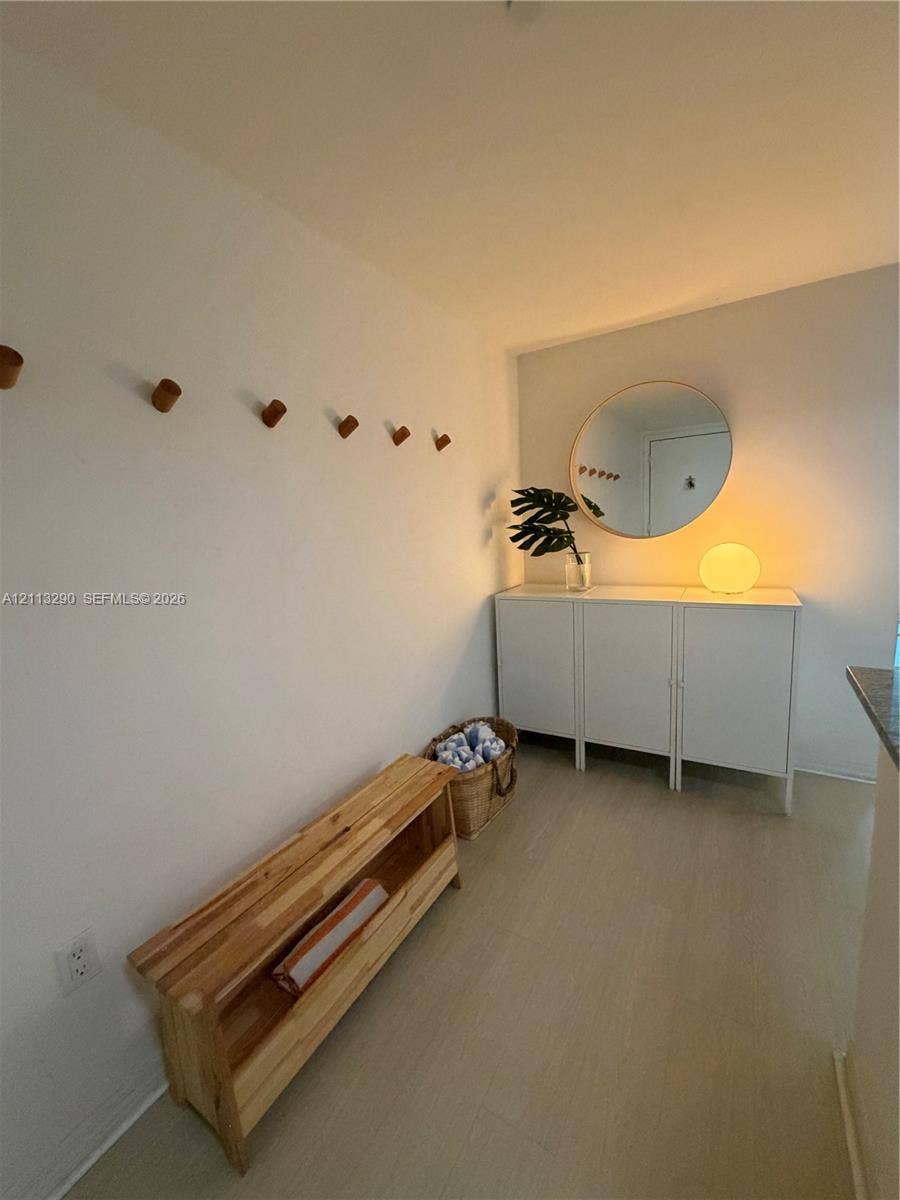 951 Brickell Avenue, #405, Miami, Miami, FL 33131 Wall-mounted wood peg hooks, circular wall mirror, and wood-finish flooring