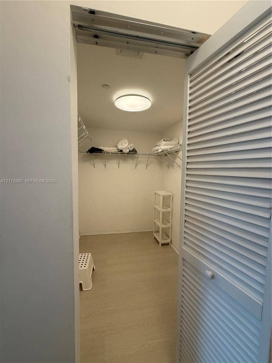 951 Brickell Avenue, #405, Miami, Miami, FL 33131 Storage closet featuring white louvered doors, neutral wood-finish flooring, and built-in wire shelving