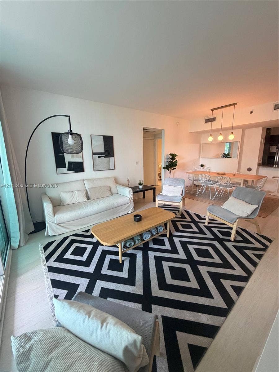 951 Brickell Avenue, #405, Miami, Miami, FL 33131 Open-concept interior featuring wood-finish flooring, recessed lighting, and a linear three-pendant light fixture over the dining area