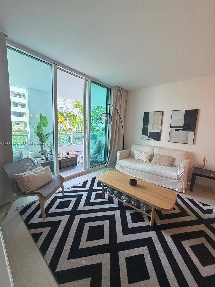 951 Brickell Avenue, #405, Miami, Miami, FL 33131 Floor-to-ceiling glass sliding doors, private balcony with metal railing, and neutral wall finishes