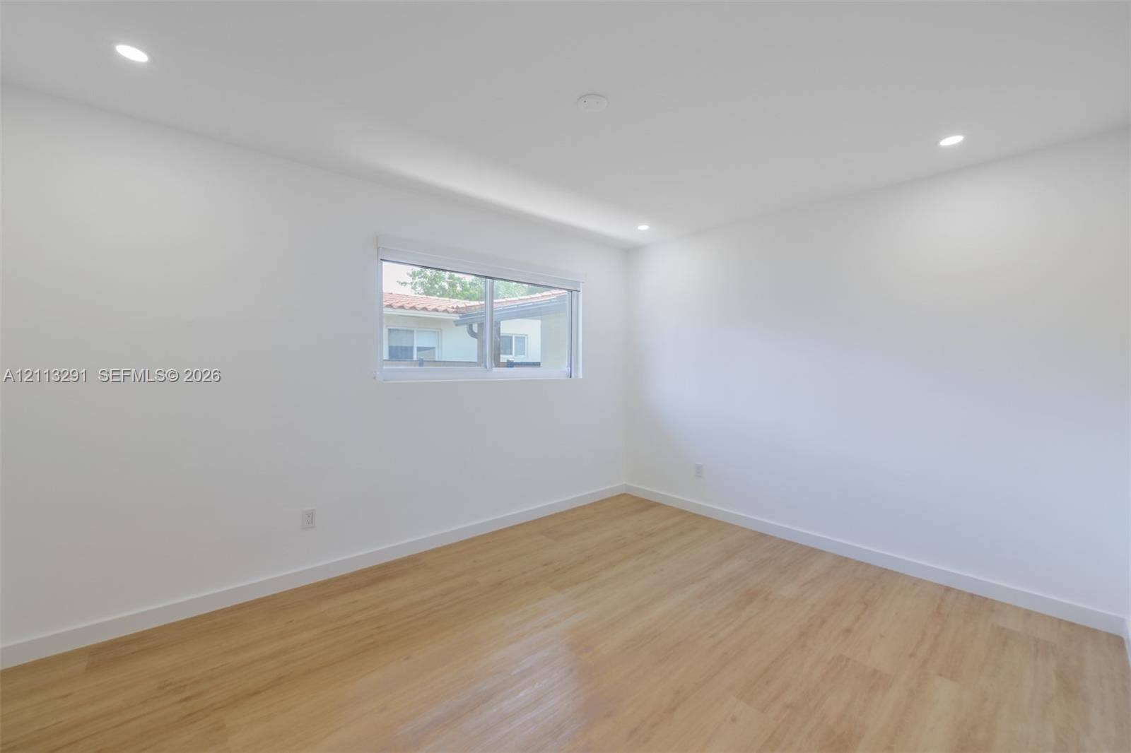Interior space featuring recessed lighting, wood-finish flooring, and a sliding window