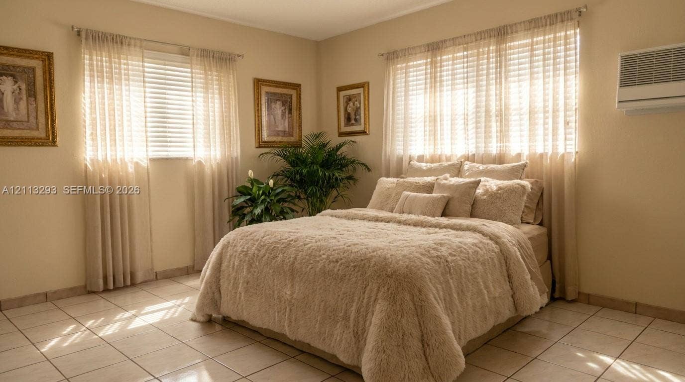 Neutral-toned walls featuring large-format ceramic tile flooring, horizontal slat blinds, and a wall-mounted climate control unit