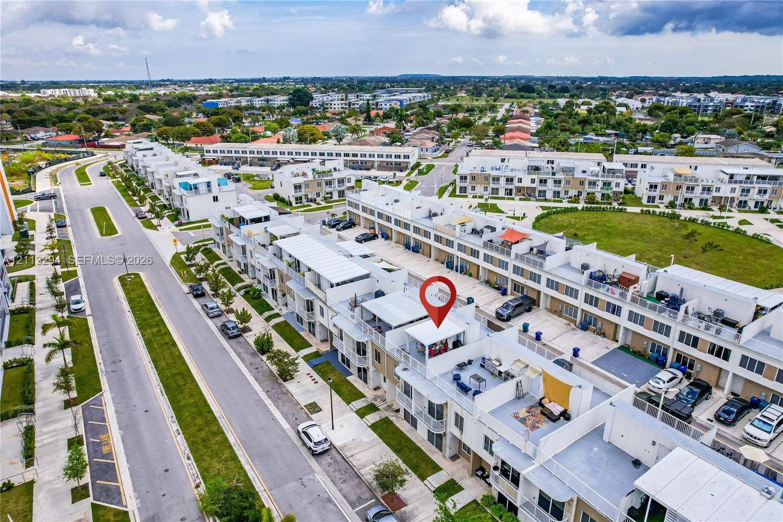 25880 SW 139th Path, #0, Homestead, FL 33032 Aerial perspective of a multi-level residential structure featuring a private rooftop terrace, balcony spaces, and paved driveway parking