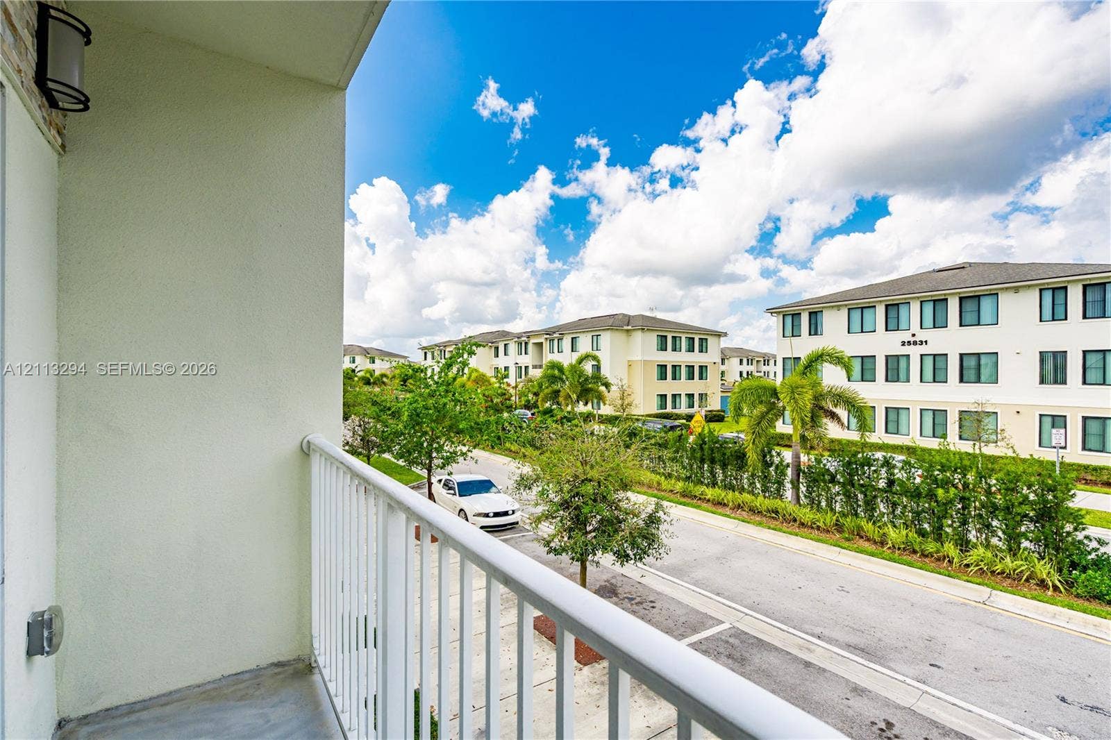 25880 SW 139th Path, #0, Homestead, FL 33032 Covered balcony featuring concrete flooring, white metal railing, and wall-mounted exterior lighting