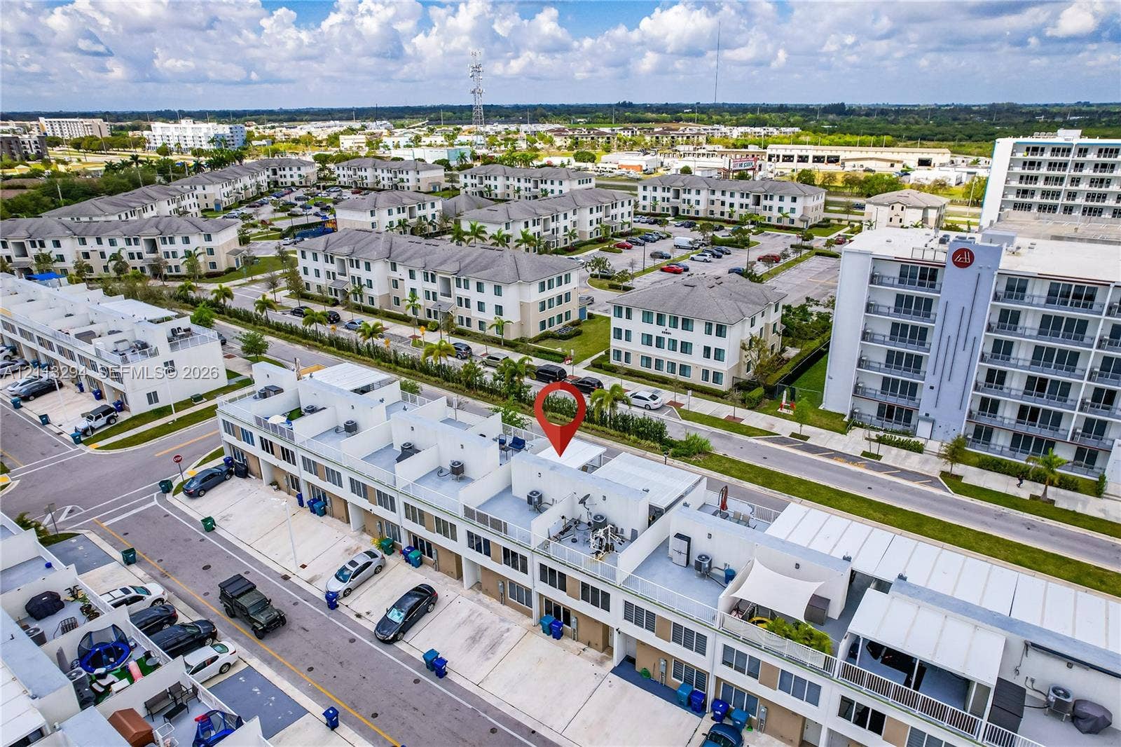 25880 SW 139th Path, #0, Homestead, FL 33032 Aerial perspective of a multi-level residential structure featuring white exterior facades, flat rooflines, and rooftop terraces with metal railing enclosures