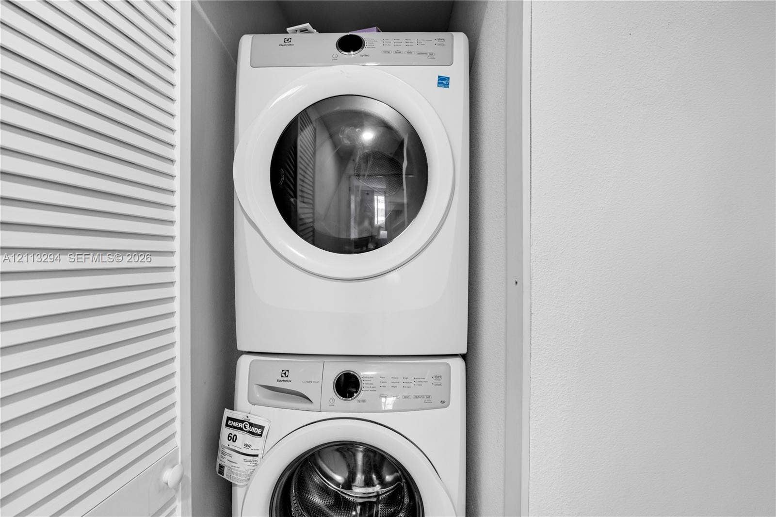 25880 SW 139th Path, #0, Homestead, FL 33032 Stackable white front-load washer and dryer unit enclosed within a louvered-door closet
