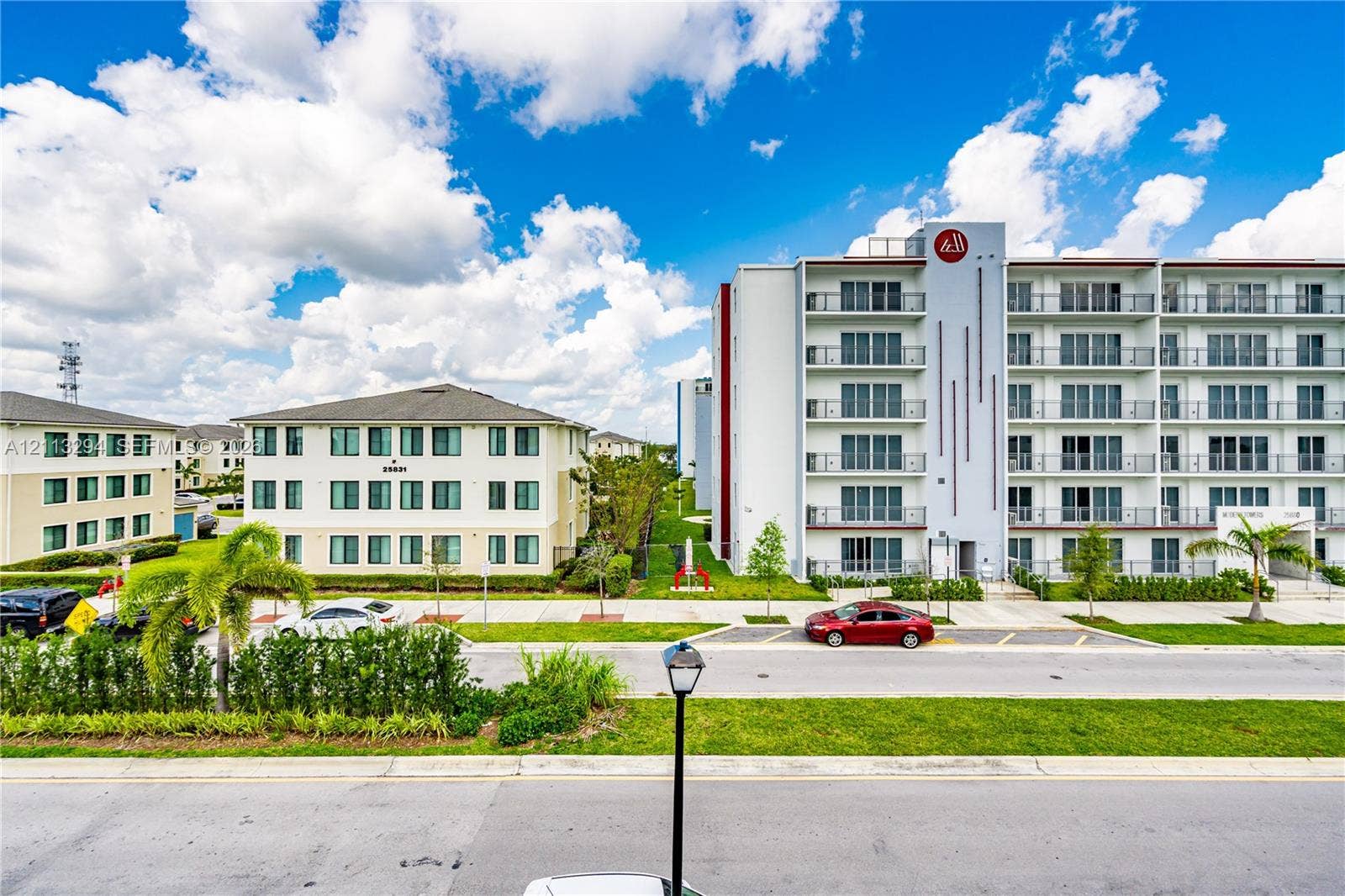 25880 SW 139th Path, #0, Homestead, FL 33032 Multi-story residential complex featuring concrete facade, private balconies, paved surface parking, and manicured perimeter landscaping