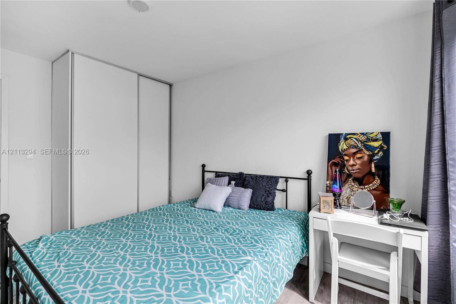 25880 SW 139th Path, #0, Homestead, FL 33032 Room featuring neutral wall paint, wood-finish flooring, and a floor-to-ceiling built-in wardrobe with sliding doors