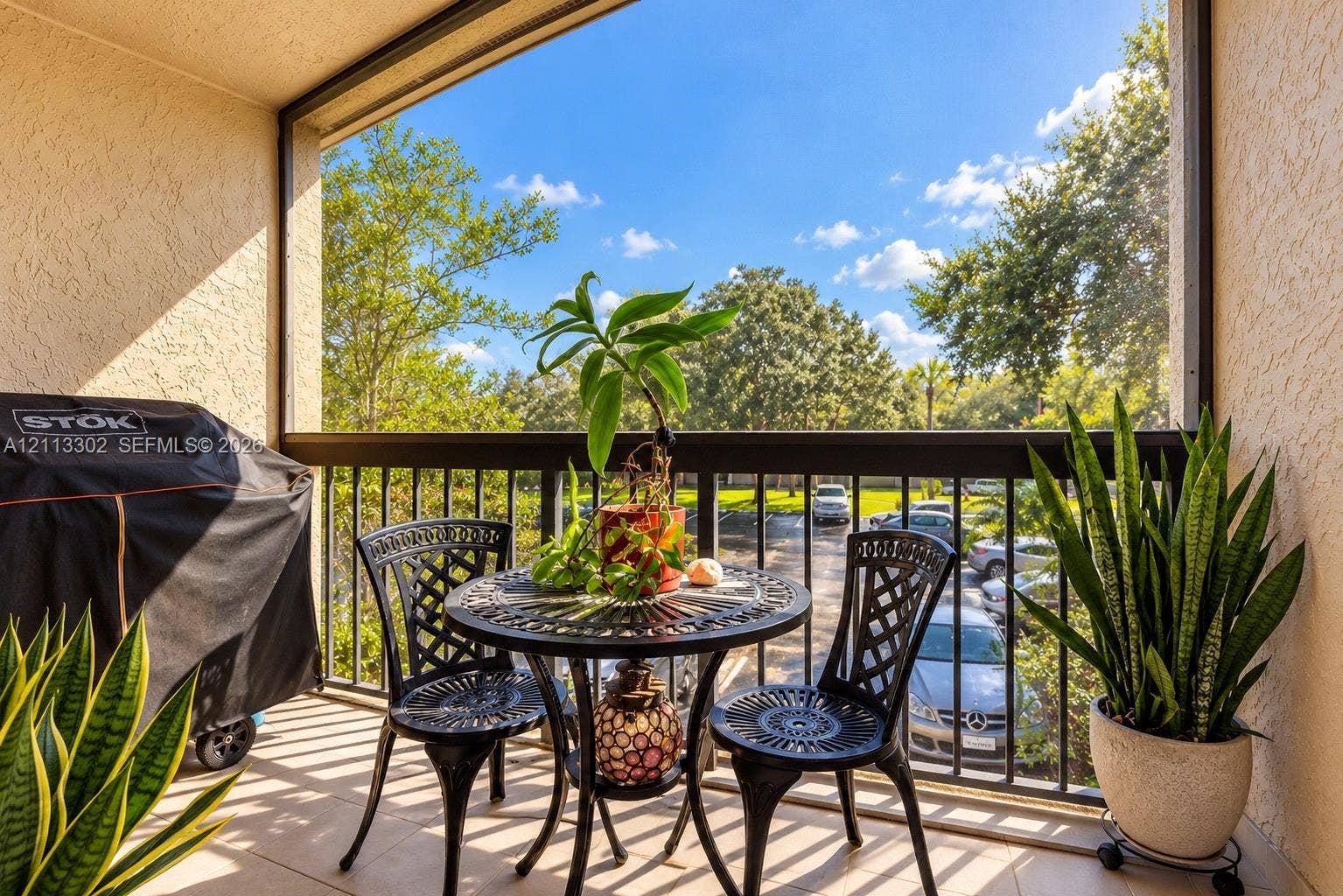9450 Meadowood Drive, #202, Fort Pierce, FL 34951 Screened balcony featuring tile flooring, textured wall finishes, and metal railings