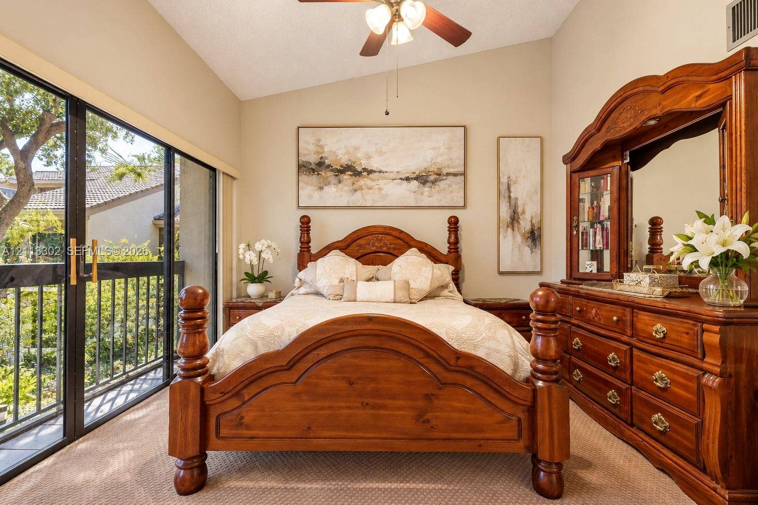 9450 Meadowood Drive, #202, Fort Pierce, FL 34951 Vaulted ceilings, ceiling fan with integrated lighting, and large sliding glass doors opening to a balcony with metal railings
