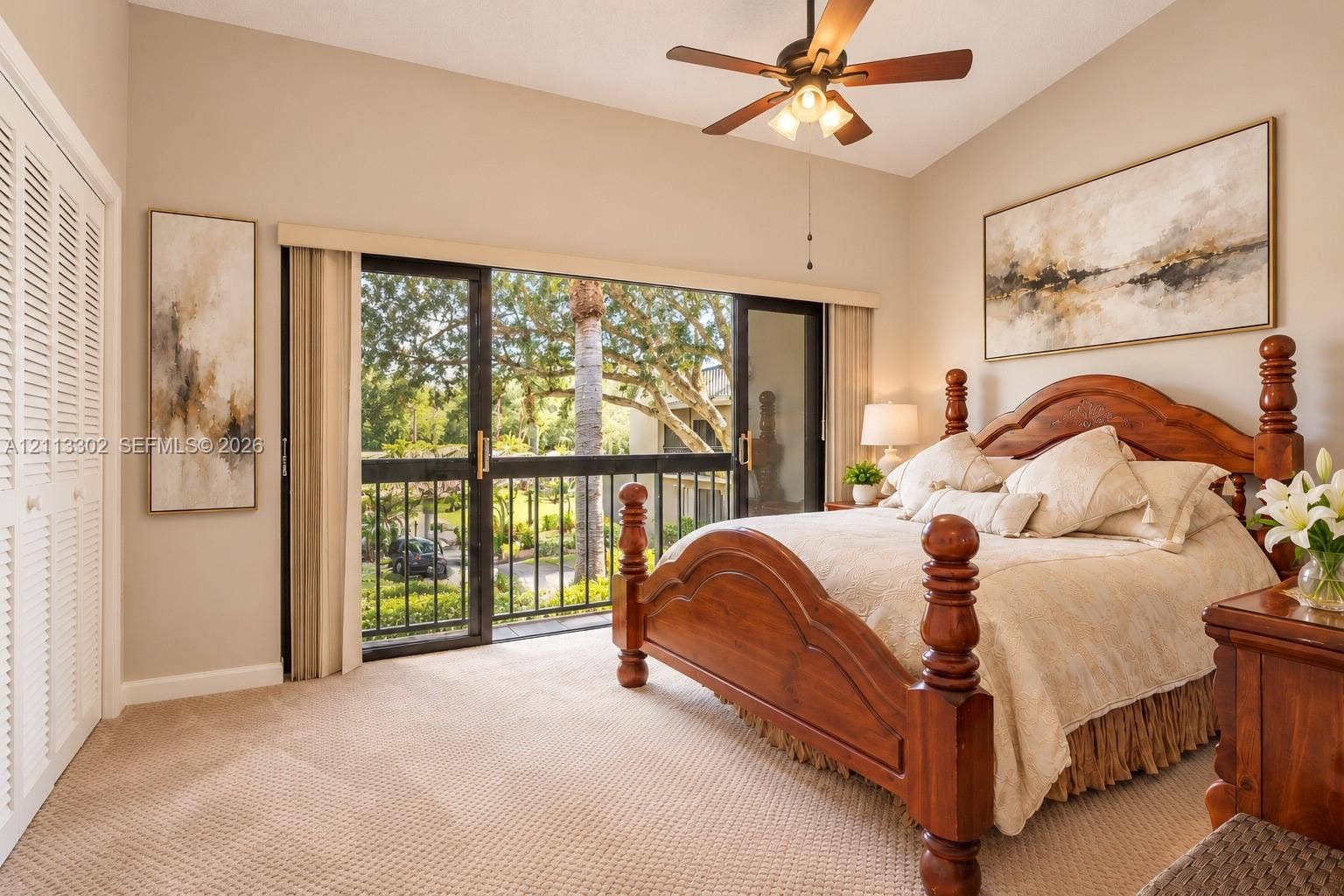 9450 Meadowood Drive, #202, Fort Pierce, FL 34951 Vaulted ceilings featuring a central paddle fan, wall-to-wall carpeting, floor-to-ceiling sliding glass doors with metal frame, and bi-fold closet doors