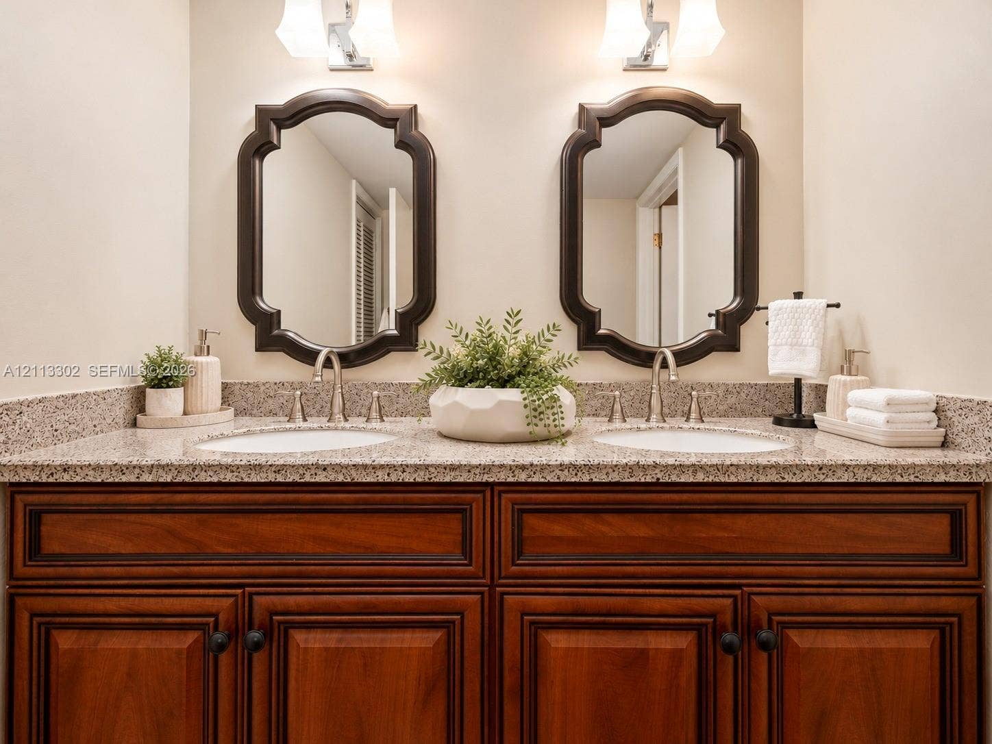 9450 Meadowood Drive, #202, Fort Pierce, FL 34951 Primary Bathroom Dual-vanity cabinet stone countertop with wood-finish