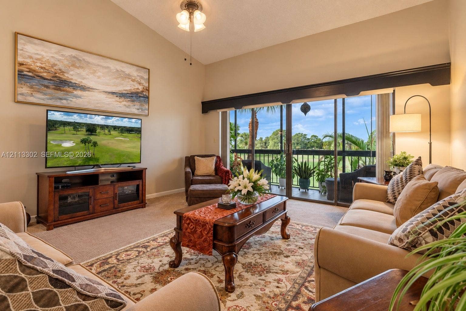 9450 Meadowood Drive, #202, Fort Pierce, FL 34951 Vaulted ceilings, sliding glass doors, and a screened-in balcony featuring exterior railings