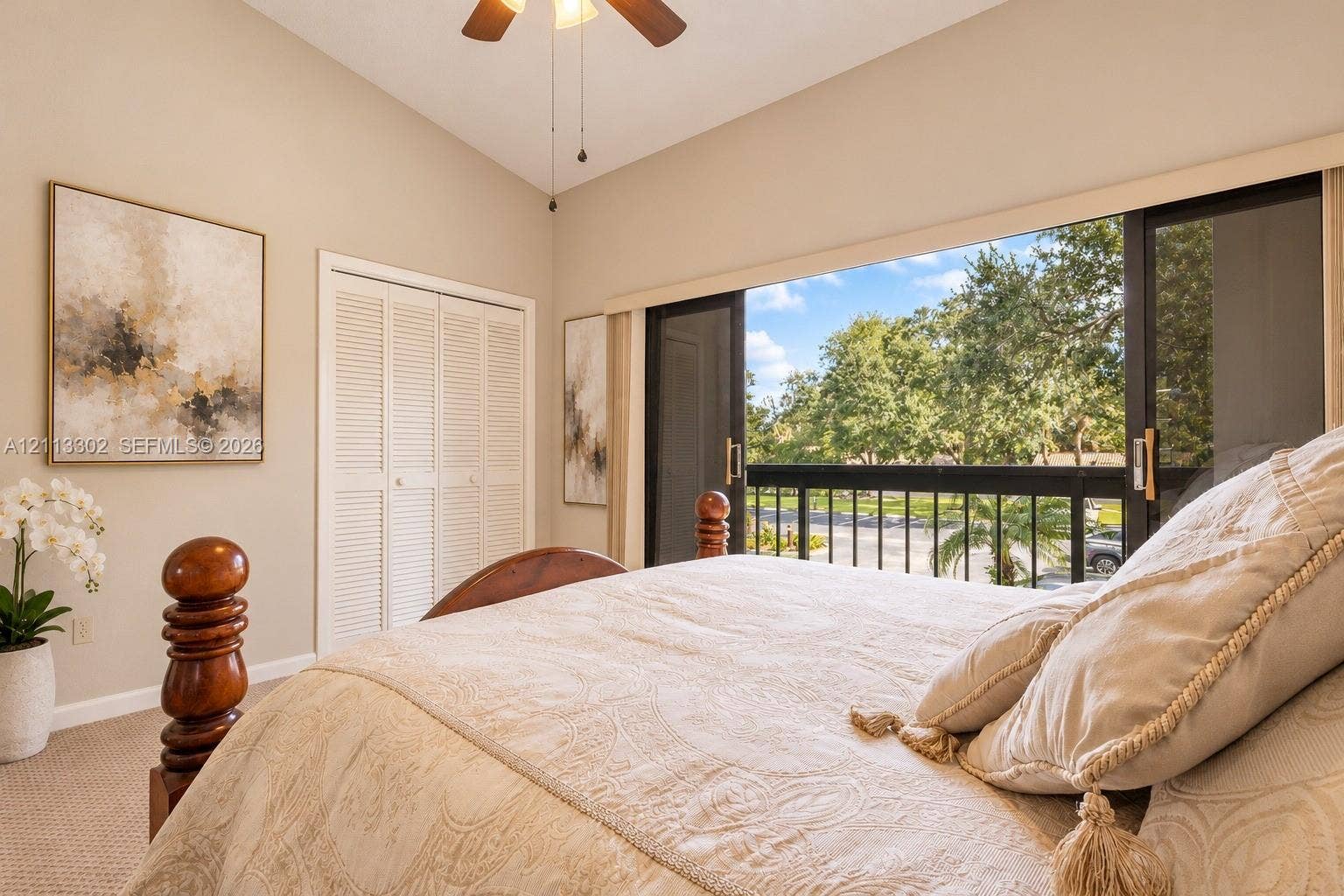 9450 Meadowood Drive, #202, Fort Pierce, FL 34951 Vaulted ceiling, sliding glass doors with access to a balcony, louvered closet doors, and a ceiling fan