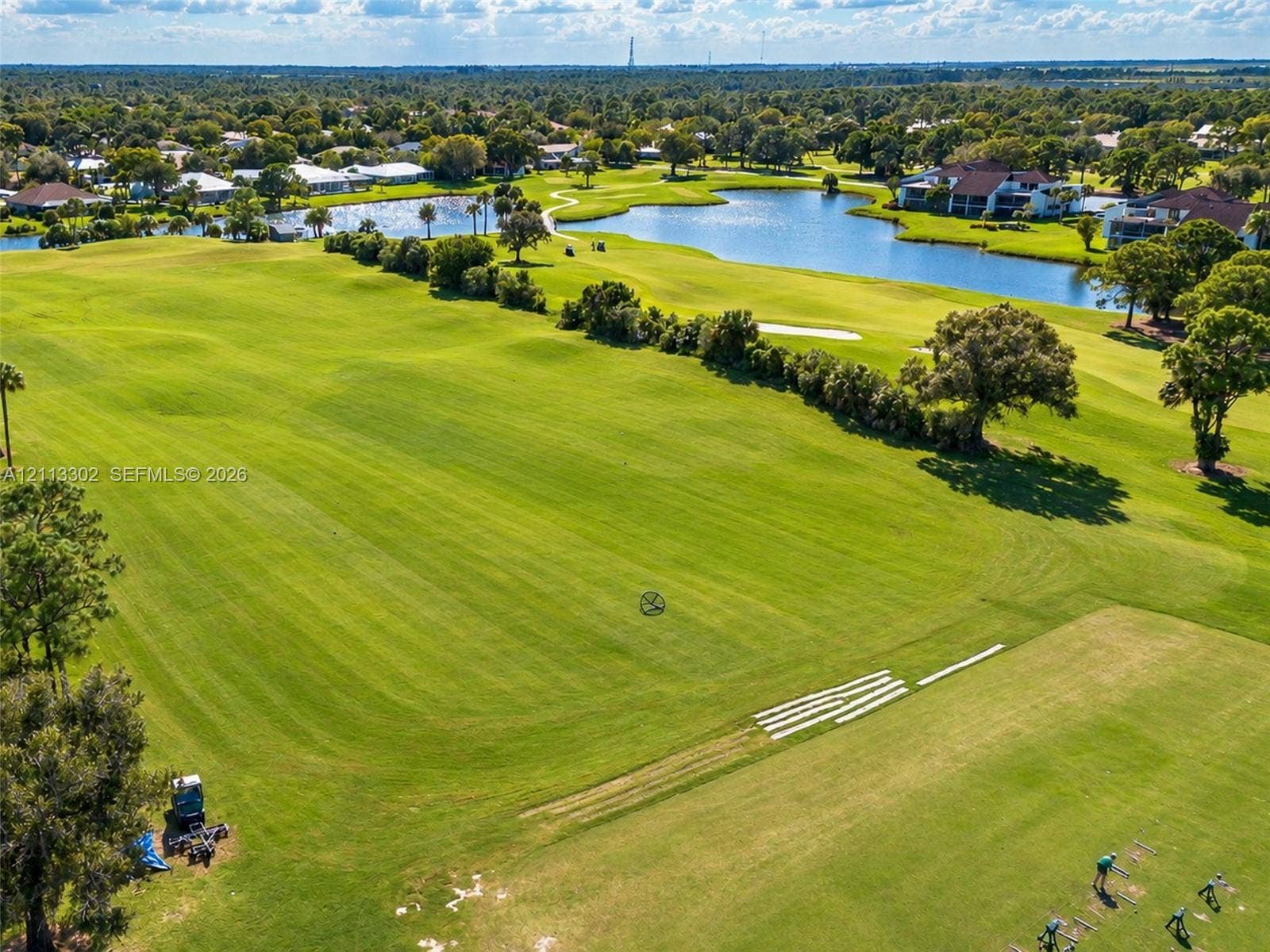9450 Meadowood Drive, #202, Fort Pierce, FL 34951 Expansive manicured lawn featuring golf course fairways, mature tree clusters, and multiple water features