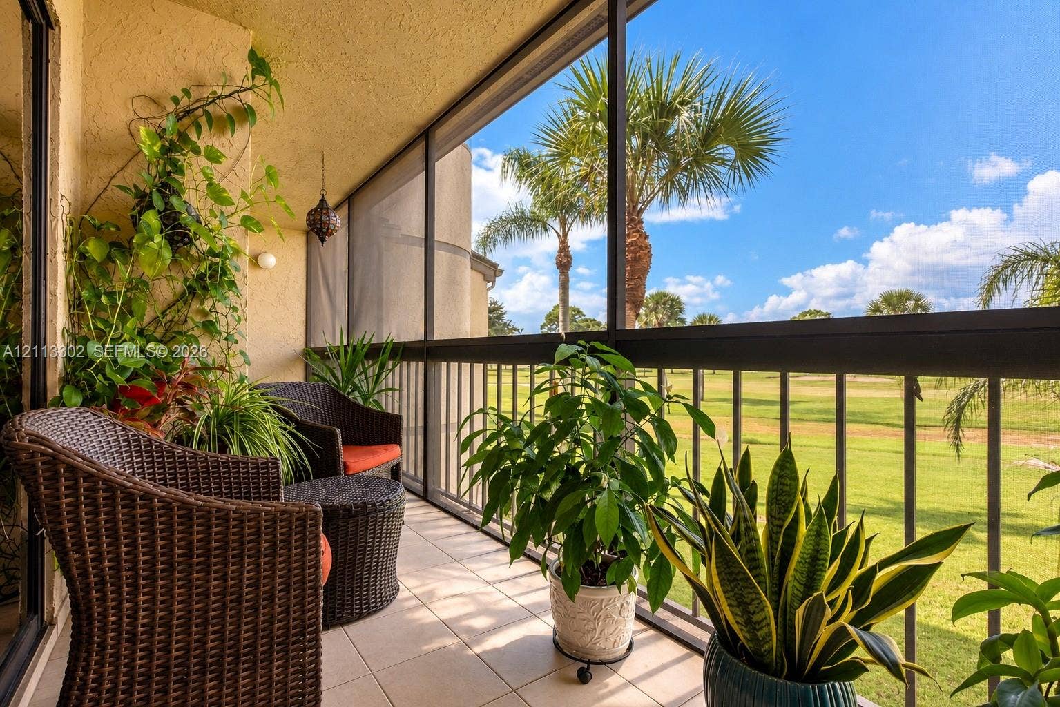 9450 Meadowood Drive, #202, Fort Pierce, FL 34951 Screened-in balcony featuring tile flooring, metal railings, and stucco exterior walls