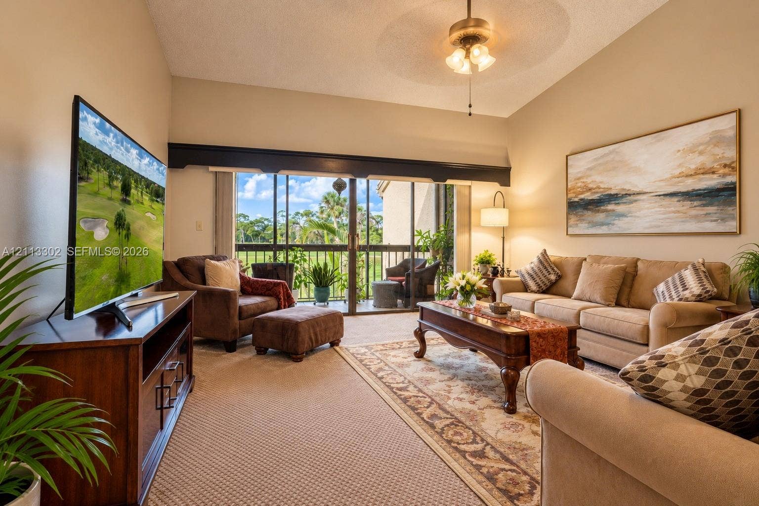 9450 Meadowood Drive, #202, Fort Pierce, FL 34951 Vaulted ceilings, expansive glass sliding doors, and a ceiling fan with integrated lighting