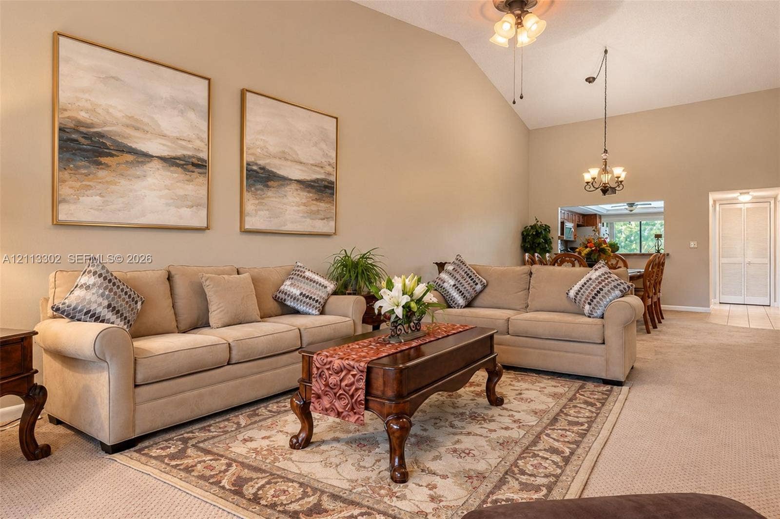 9450 Meadowood Drive, #202, Fort Pierce, FL 34951 Vaulted ceilings, neutral wall tones, multi-arm chandelier lighting, and built-in closet doors