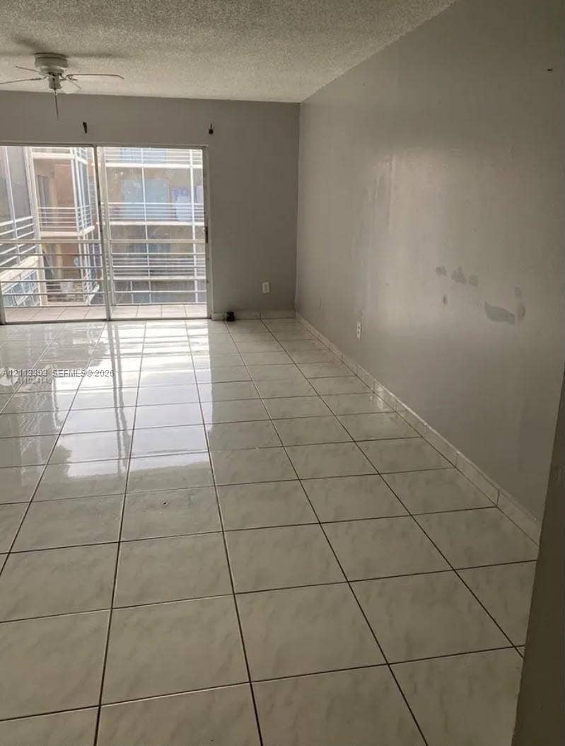 Lauderdale Lakes, FL 33313 Ceramic tile flooring, neutral wall finishes, sliding glass door, and a ceiling fan