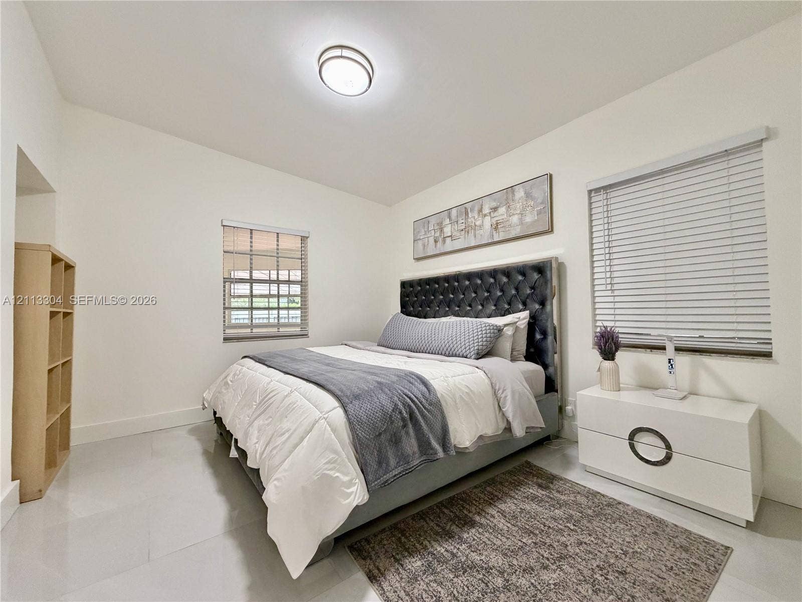 1810 SW 5th Avenue, #n/a, Miami, Miami, FL 33129 Neutral-toned interior featuring large-format tile flooring, recessed ceiling lighting, two windows with horizontal blinds, and a built-in open-shelving unit