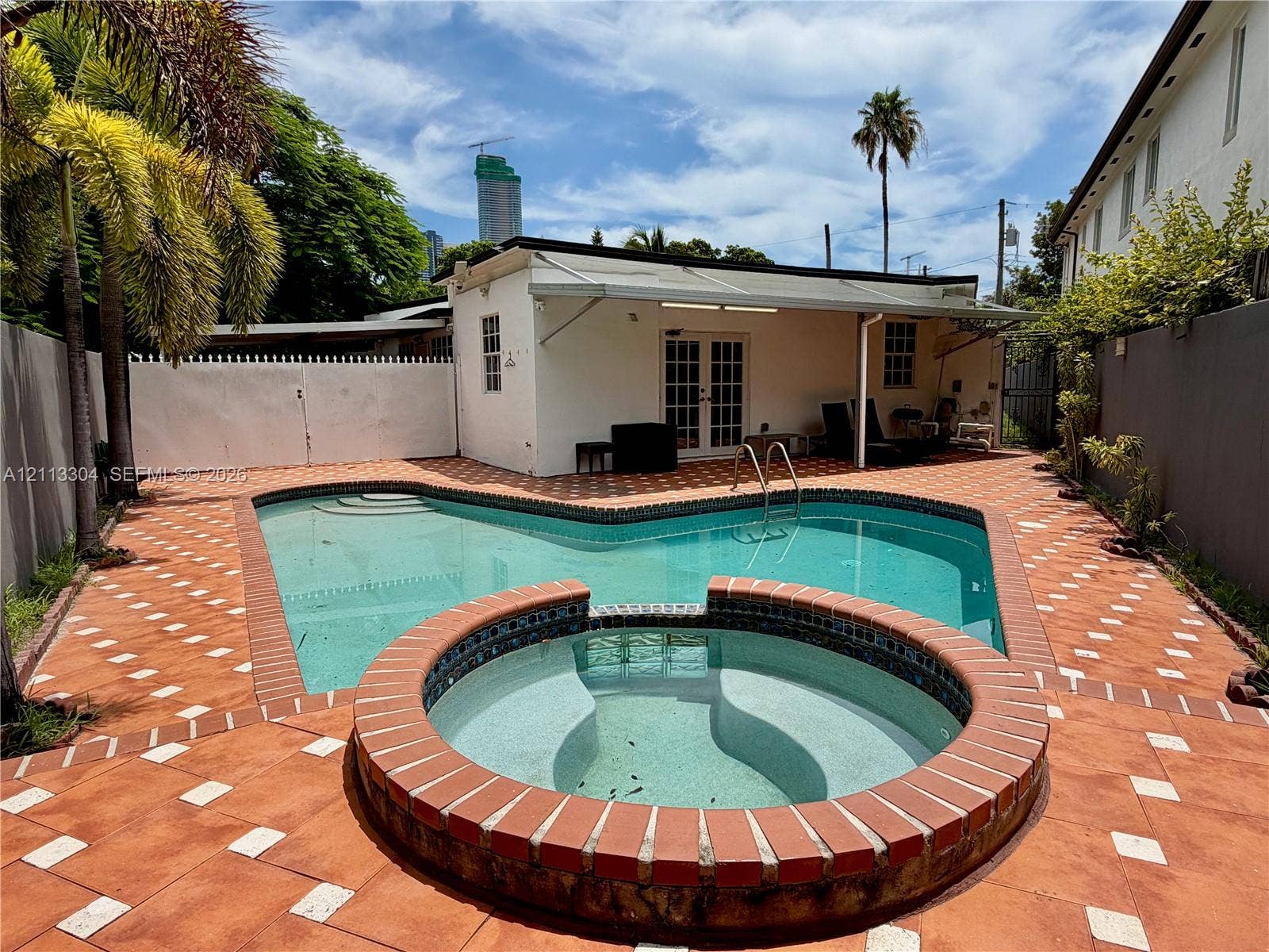 1810 SW 5th Avenue, #n/a, Miami, Miami, FL 33129 Private outdoor area featuring an in-ground swimming pool, raised circular spa with tile finish, expansive tiled patio, and solid white fencing