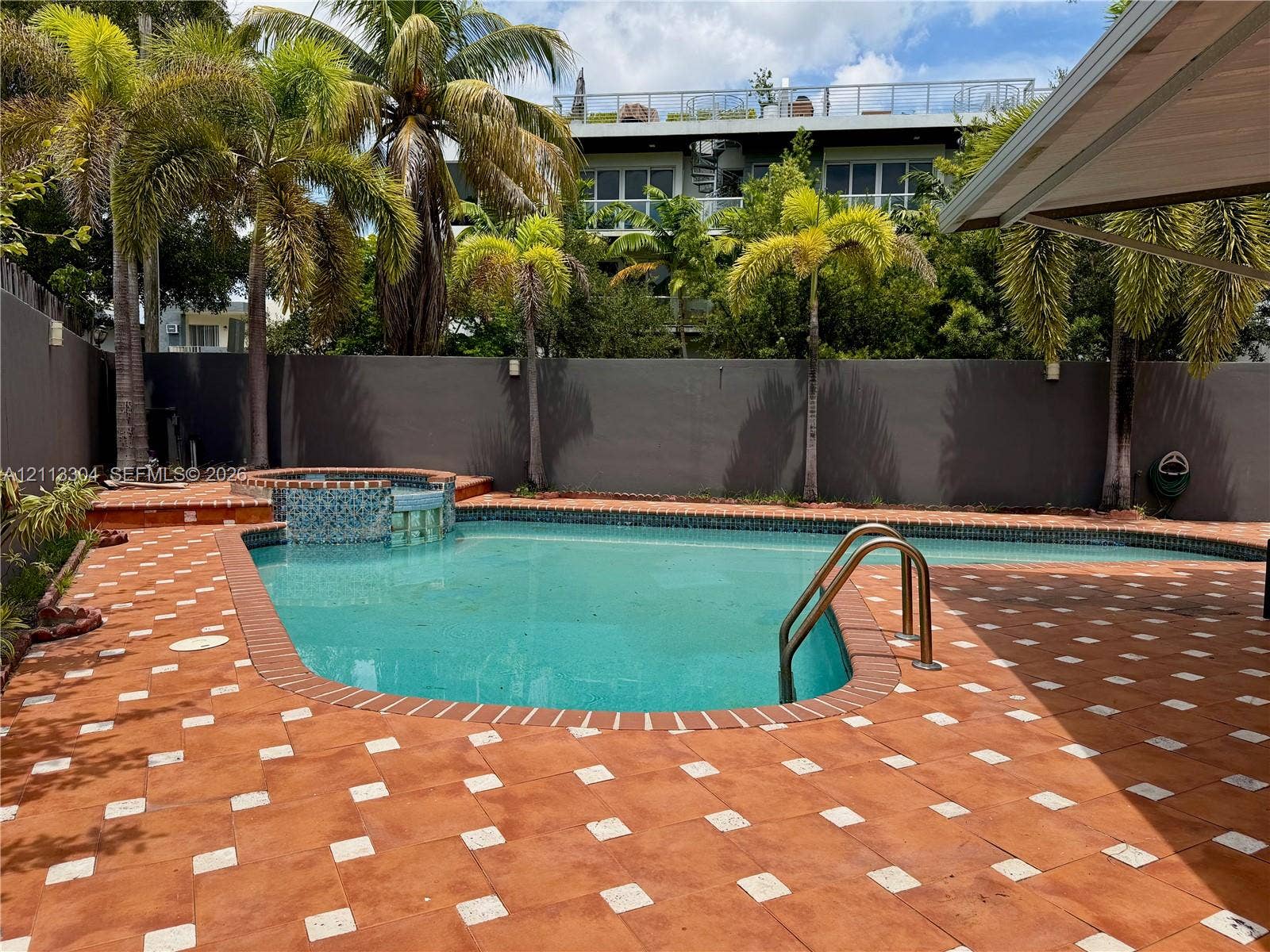 1810 SW 5th Avenue, #n/a, Miami, Miami, FL 33129 In-ground swimming pool with an integrated spa, mosaic tile detailing, and patterned paver surround