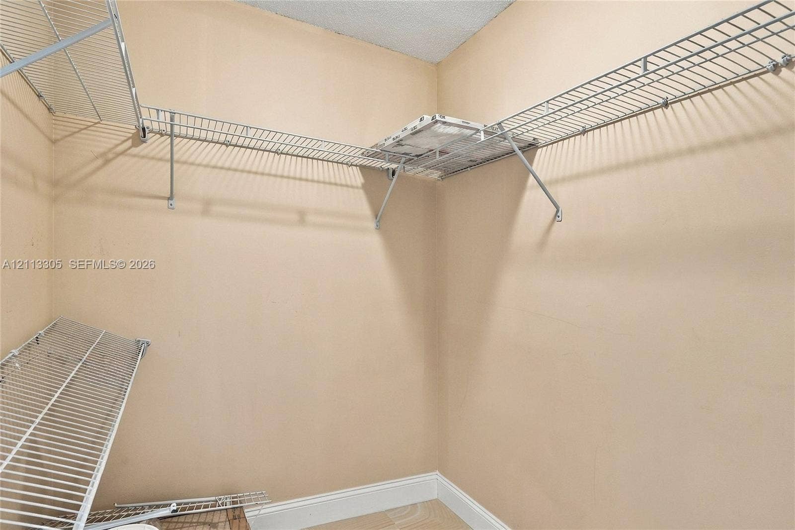 Walk-in storage space featuring multi-level white wire shelving