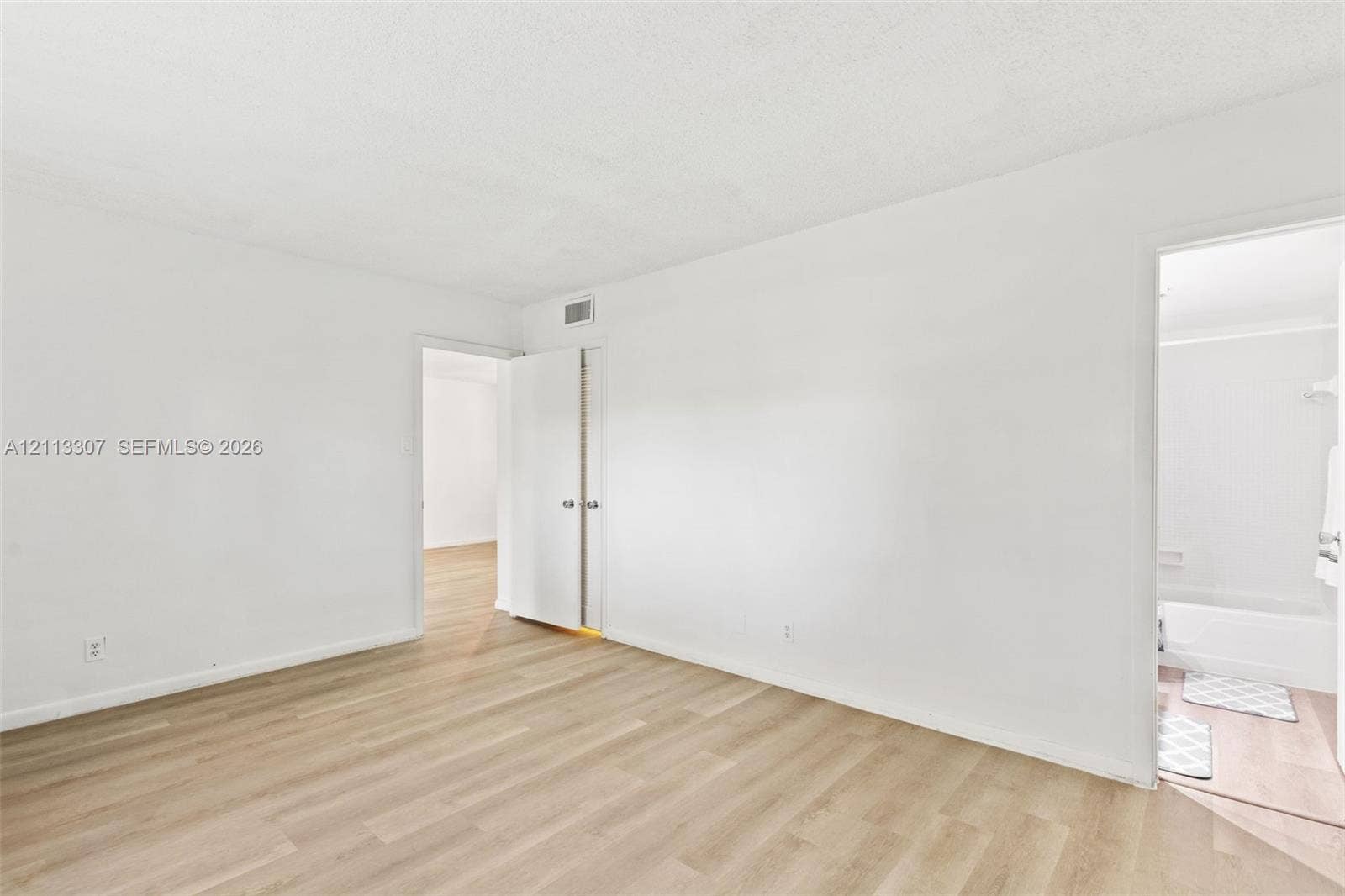 7605 NW 5th Place, #103, Margate, Margate, FL 33063 Neutral interior featuring wood-finish flooring, white walls, and a closet with double doors