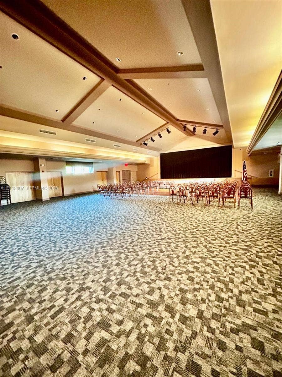 7605 NW 5th Place, #103, Margate, Margate, FL 33063 Expansive hall featuring high, multi-tiered tray ceilings with exposed beams, integrated recessed lighting, track lighting, and patterned wall-to-wall carpeting