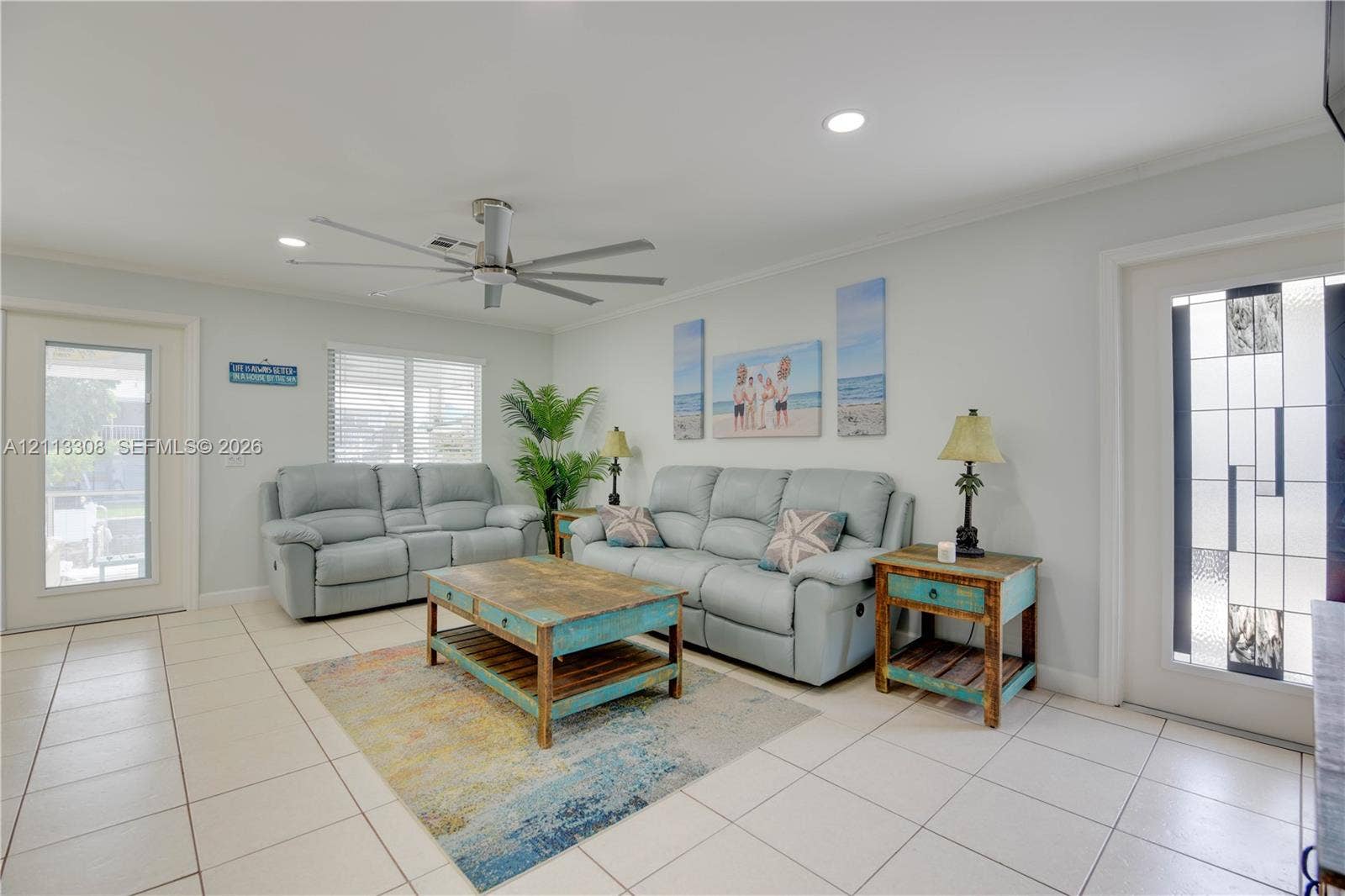 Neutral tile flooring, ceiling fan with brushed metal finish, recessed lighting, and exterior doors featuring decorative leaded glass inserts