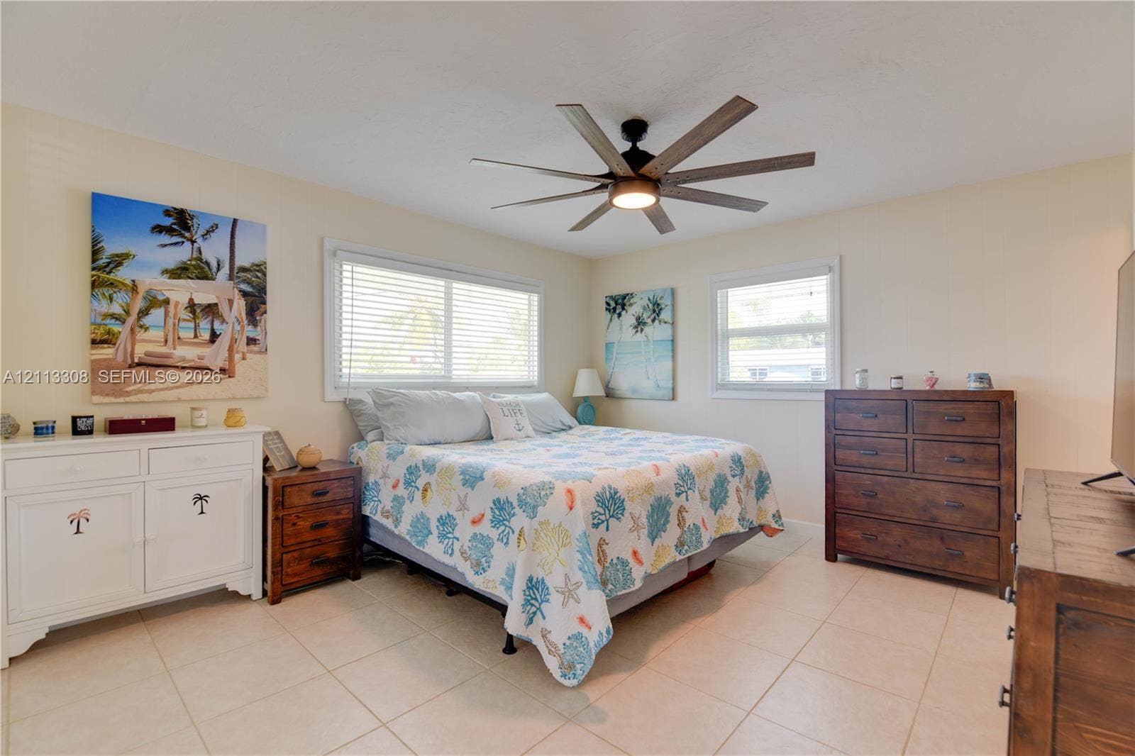 Bedroom featuring large-format tile flooring, multiple windows with blinds, and a multi-blade ceiling fan with integrated lighting