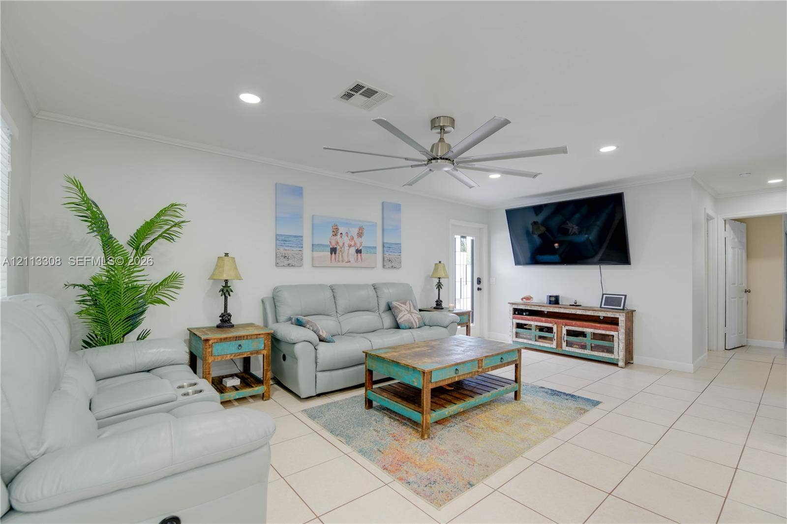 Large living area featuring neutral tile flooring, recessed lighting, and a multi-blade ceiling fan