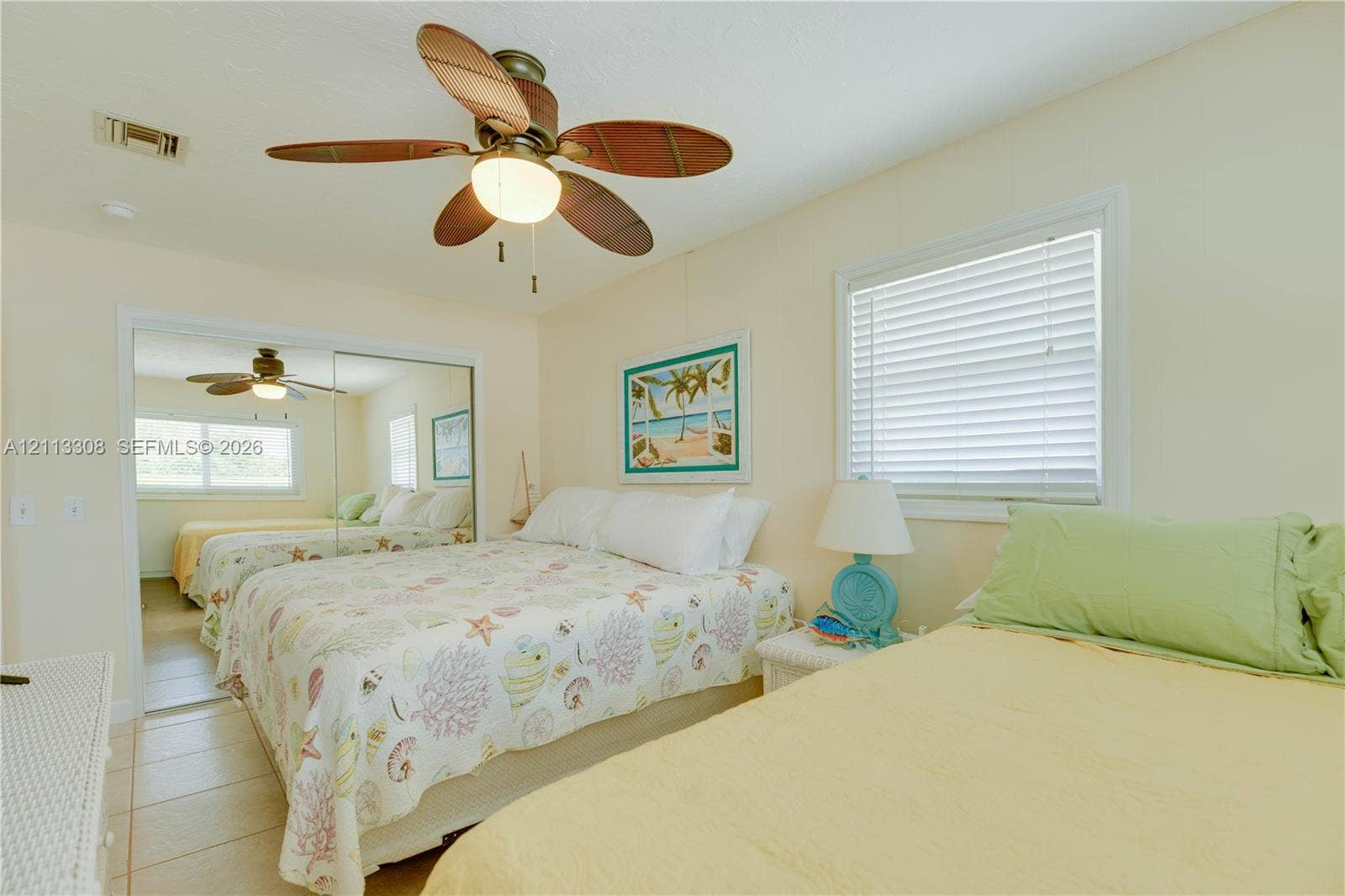 Ceiling fan with integrated lighting, tile flooring, and sliding mirror closet doors